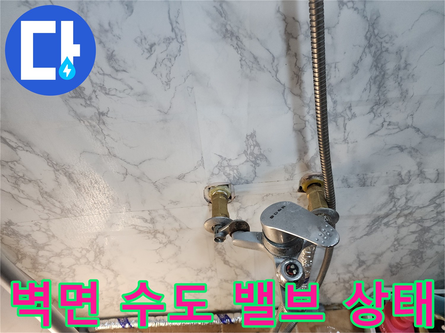 벽면에 고정된 수도 밸브와 수전 연결 호스 상세 사진