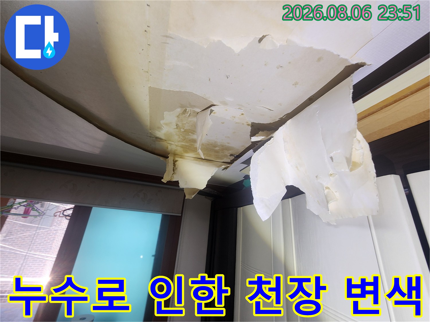 습기로 인해 부풀고 찢어진 거실 천장 도배지 사진입니다.