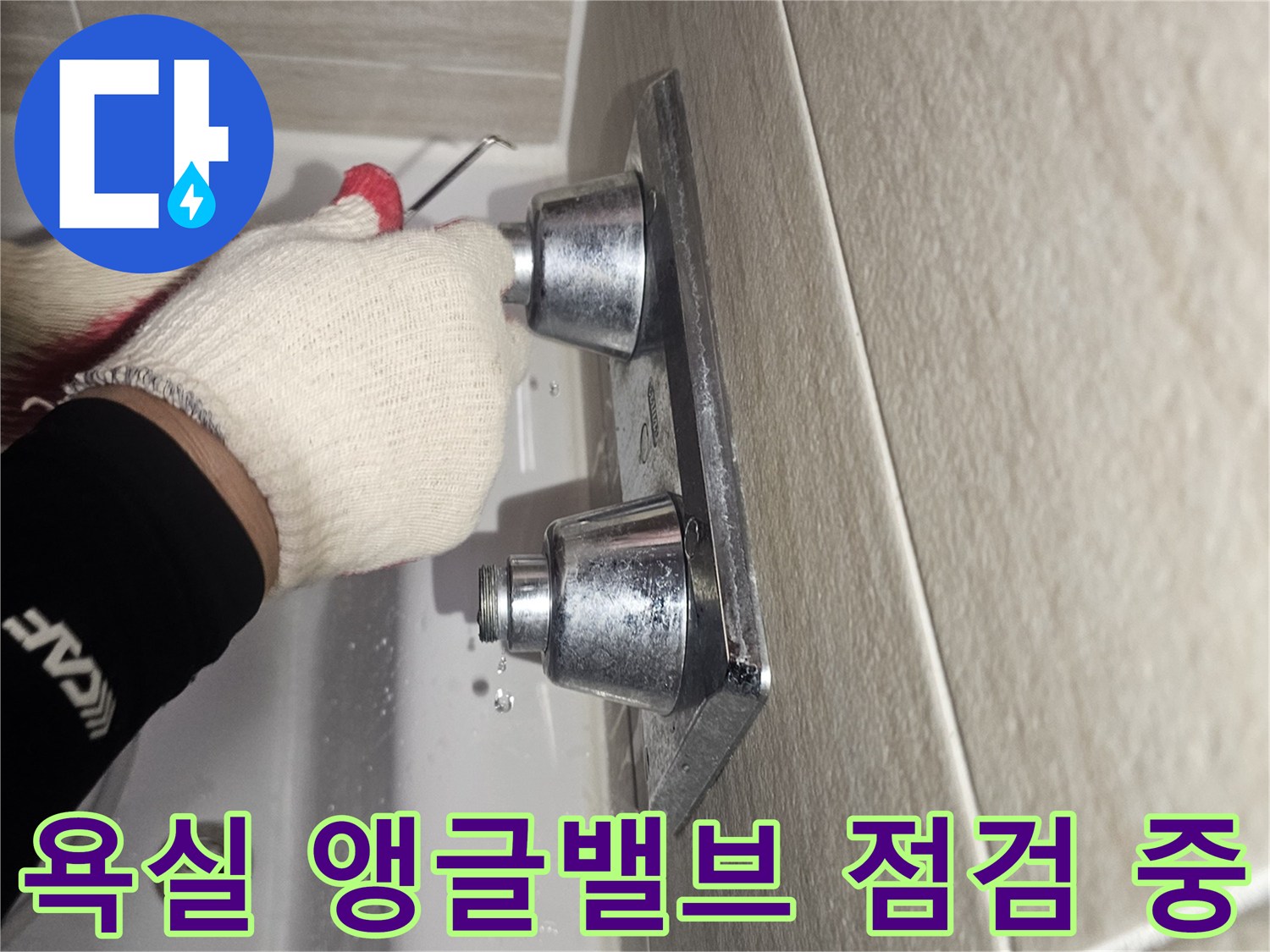 장갑을 낀 작업자가 세면대 아래 배관 연결부를 만져보며 점검하는 모습