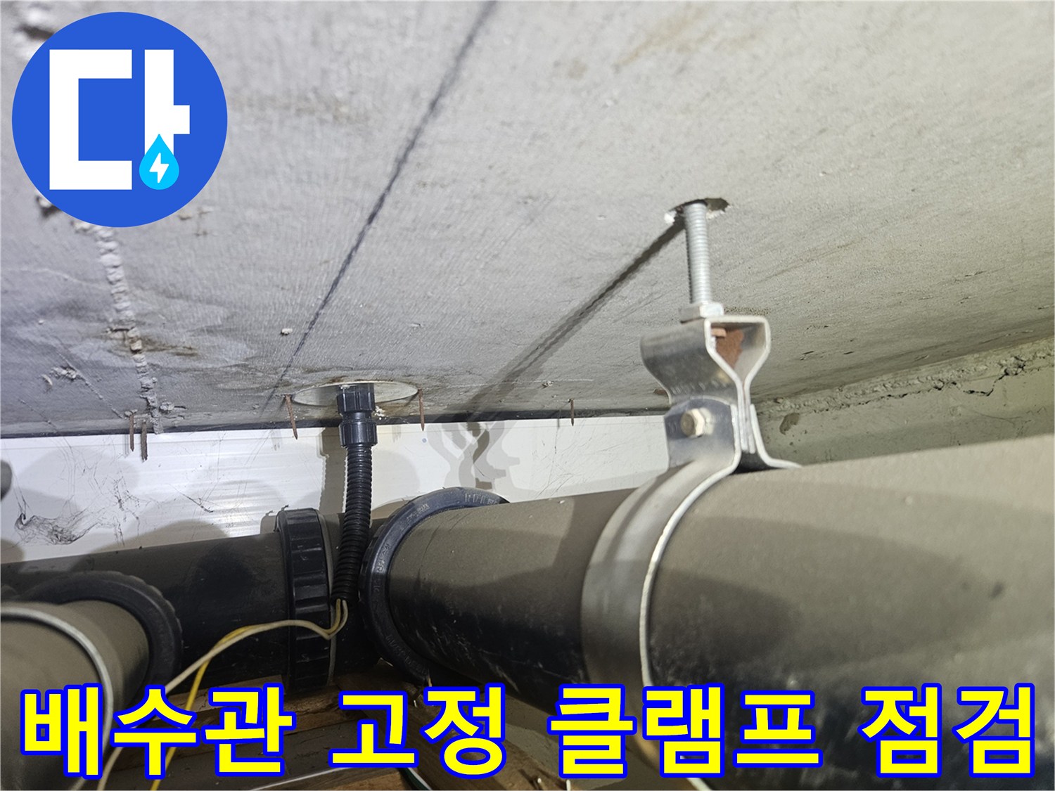 천장에 설치된 검은색 배관과 금속 지지 구조물