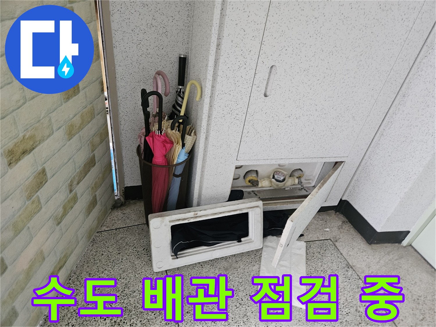 열려 있는 계량기함 속의 수도 배관과 밸브 부위