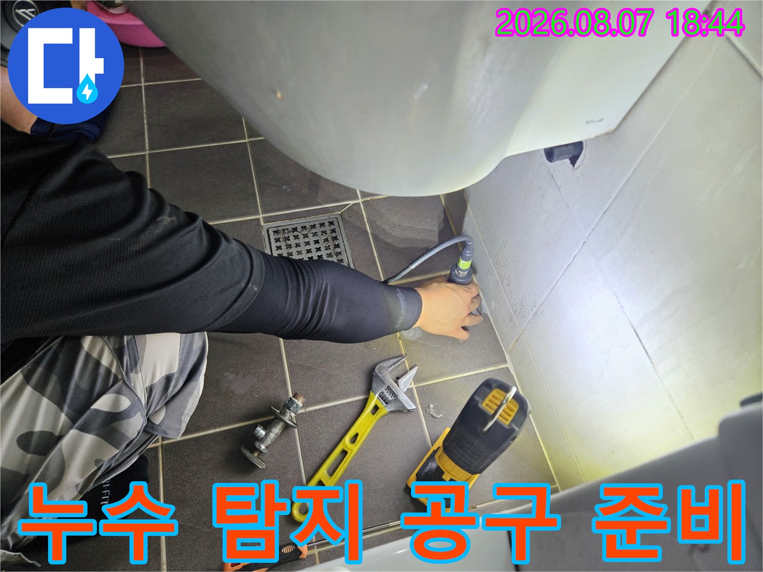 전동드릴과-몽키스패너가 놓여 있는 누수 작업 현장 모습