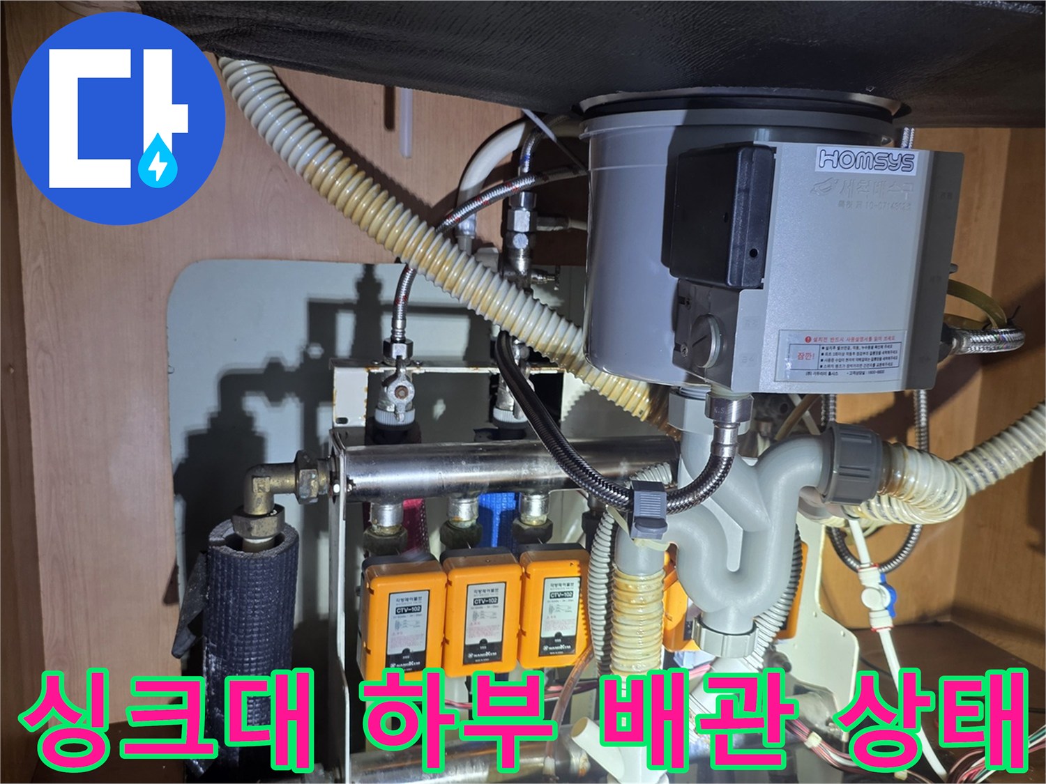 복잡하게 연결된 싱크대 하부 급수 라인과 밸브 장치