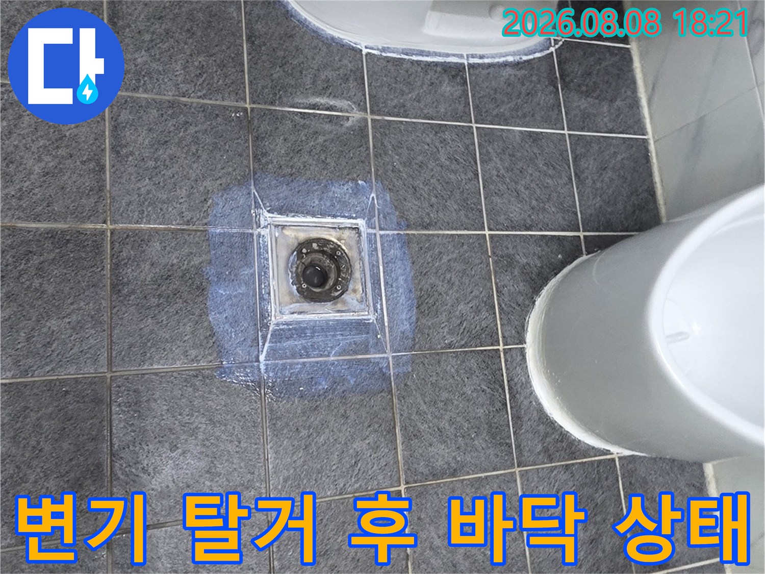 변기를 떼어낸 자리의 습한 타일과 오염된 배관 주변