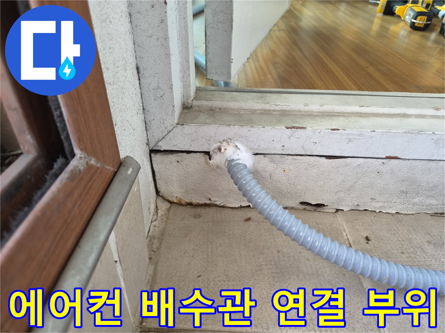 배수 호스가 벽면 틈새를 통해 외부로 이어지는 모습