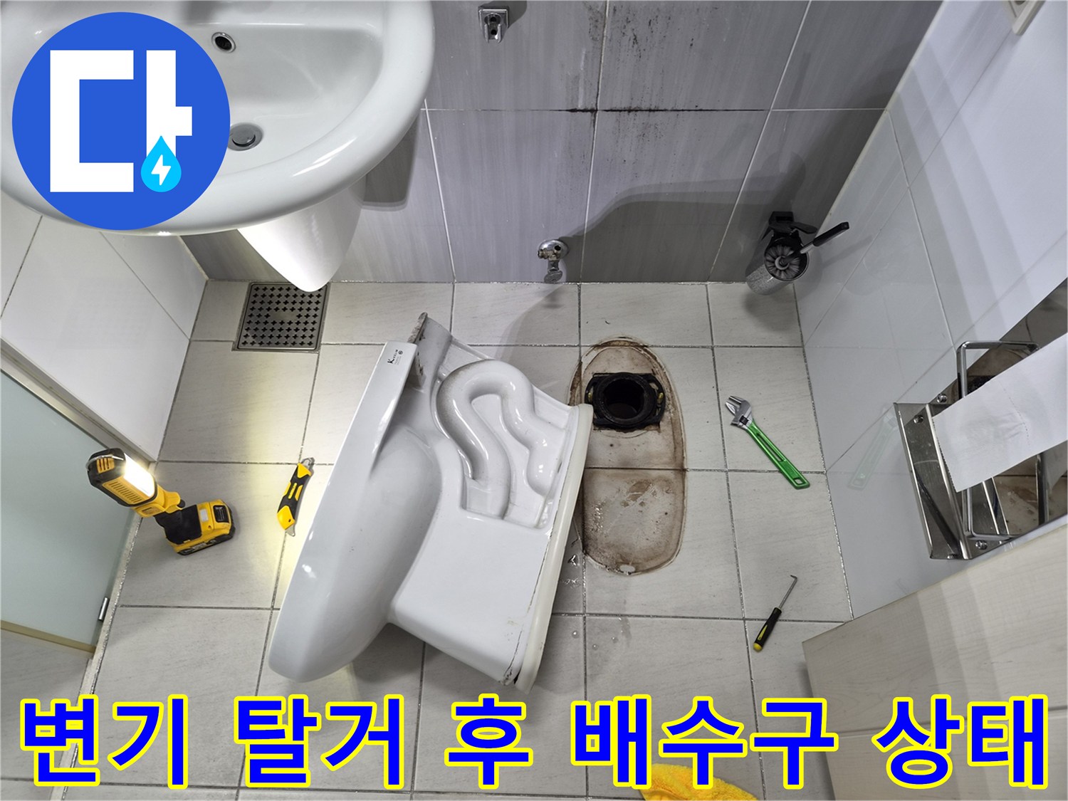 탈거된 변기 하단 배관 주변의 젖은 타일과 오염 부위