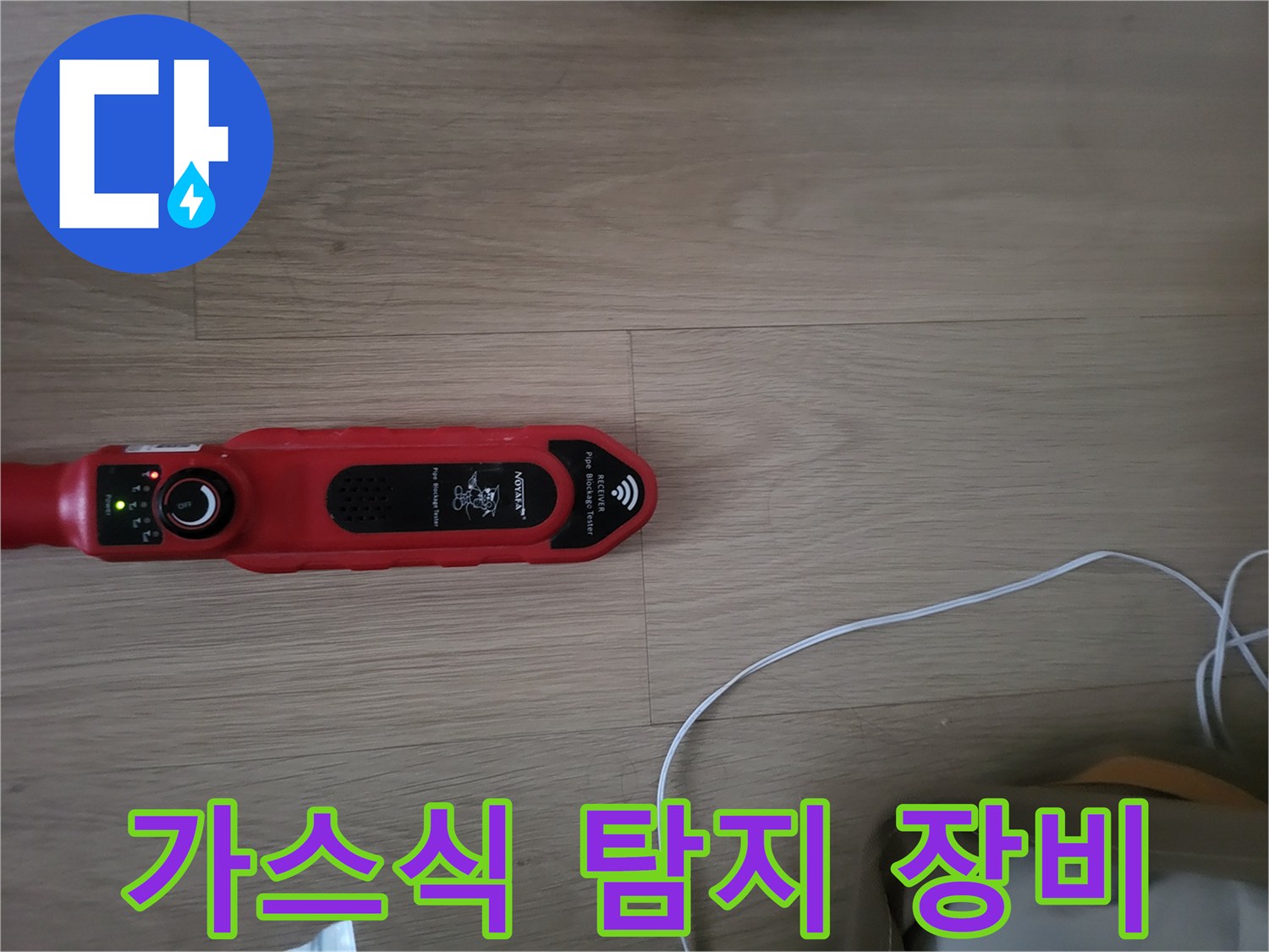 바닥재 위에 배치된 붉은색 가스 탐지기 사진입니다.