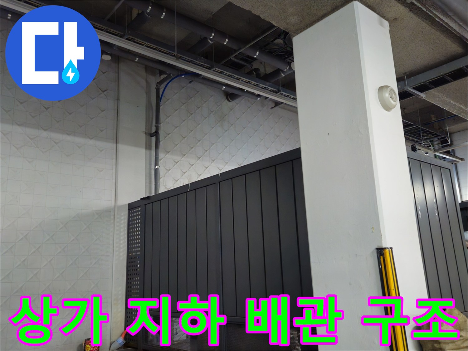 지하 주차장 천장에 설치된 금속재 배관과 벽면 기둥