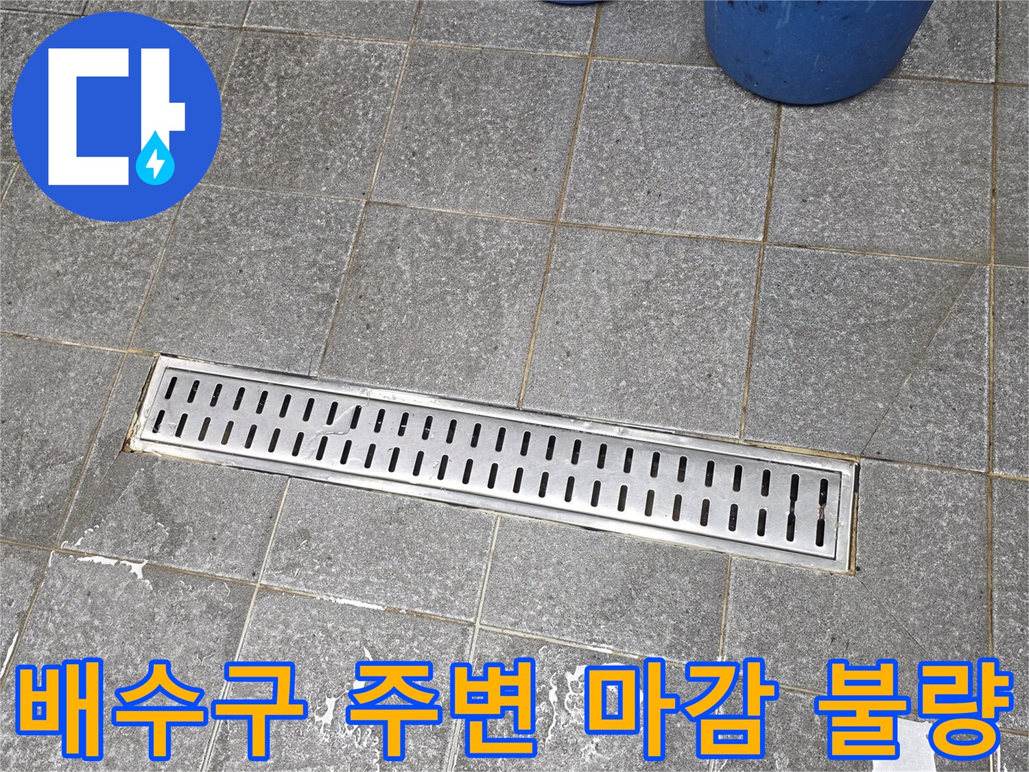 스테인리스 트렌치와 회색 타일 바닥의 접합 부위