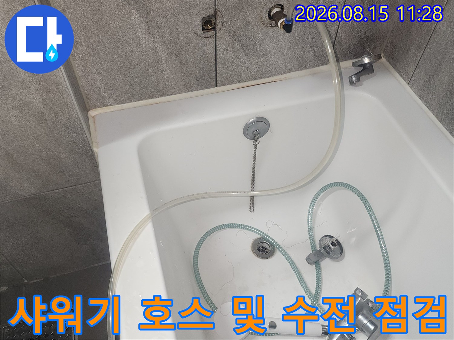 욕실 벽면에 설치된 샤워기 수전과 연결된 호스의 근접 촬영