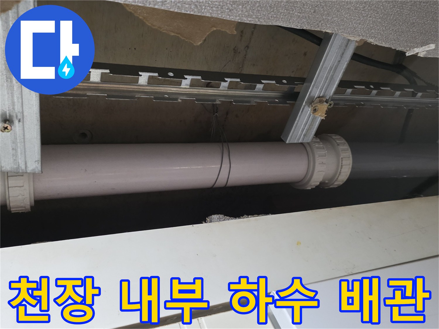 천장 안쪽의 흰색 PVC 배관과 금속 지지 구조물 사진