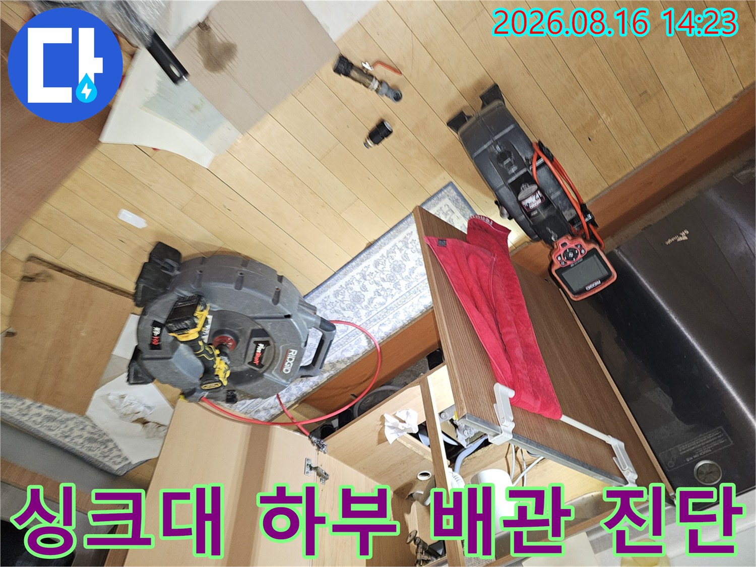 싱크대 아래쪽 배관 연결 부위를 점검하는 작업 현장 모습