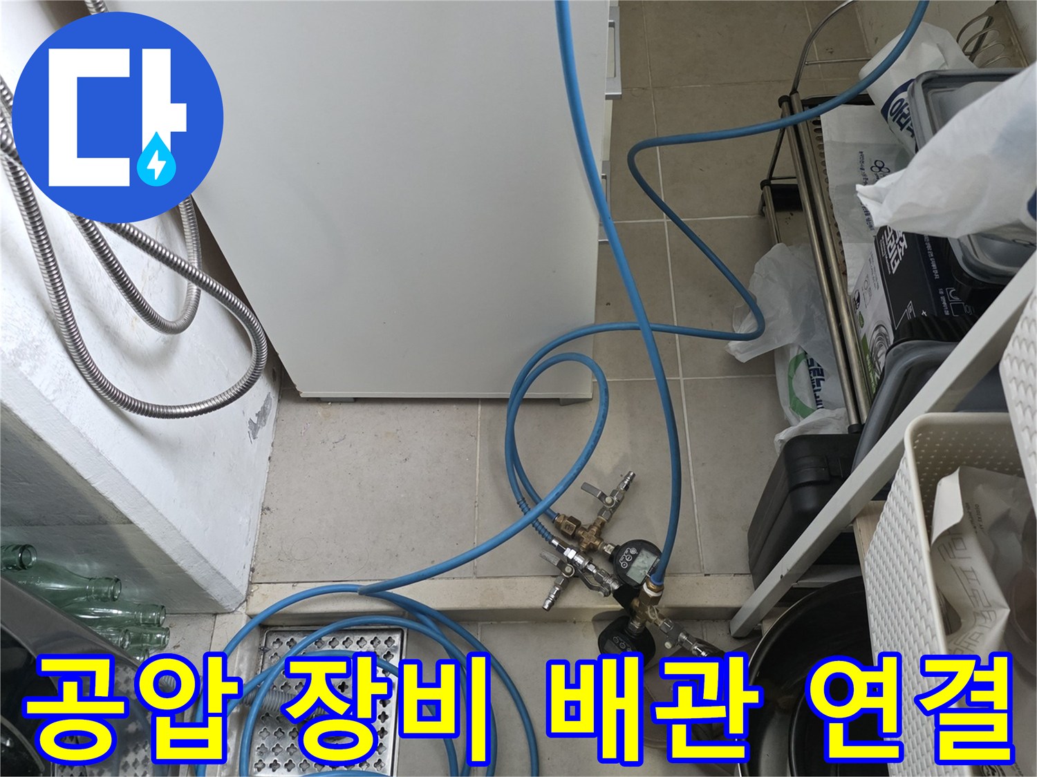누수 진단용-파란색 호스와 압력계가 설치된 싱크대 하부 배수구 모습
