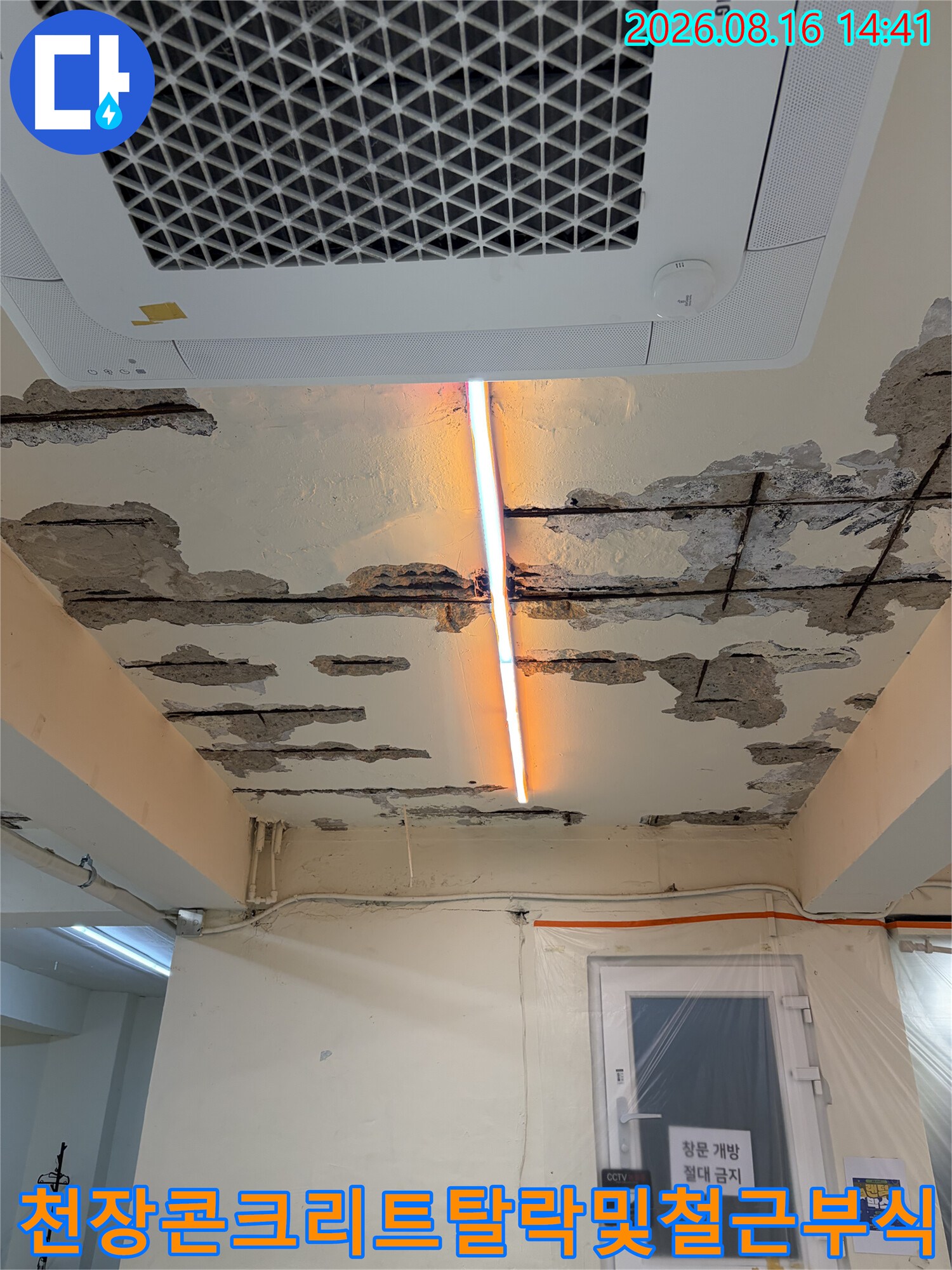 심하게 손상된 지하 천장의 콘크리트 표면과 노출 철근