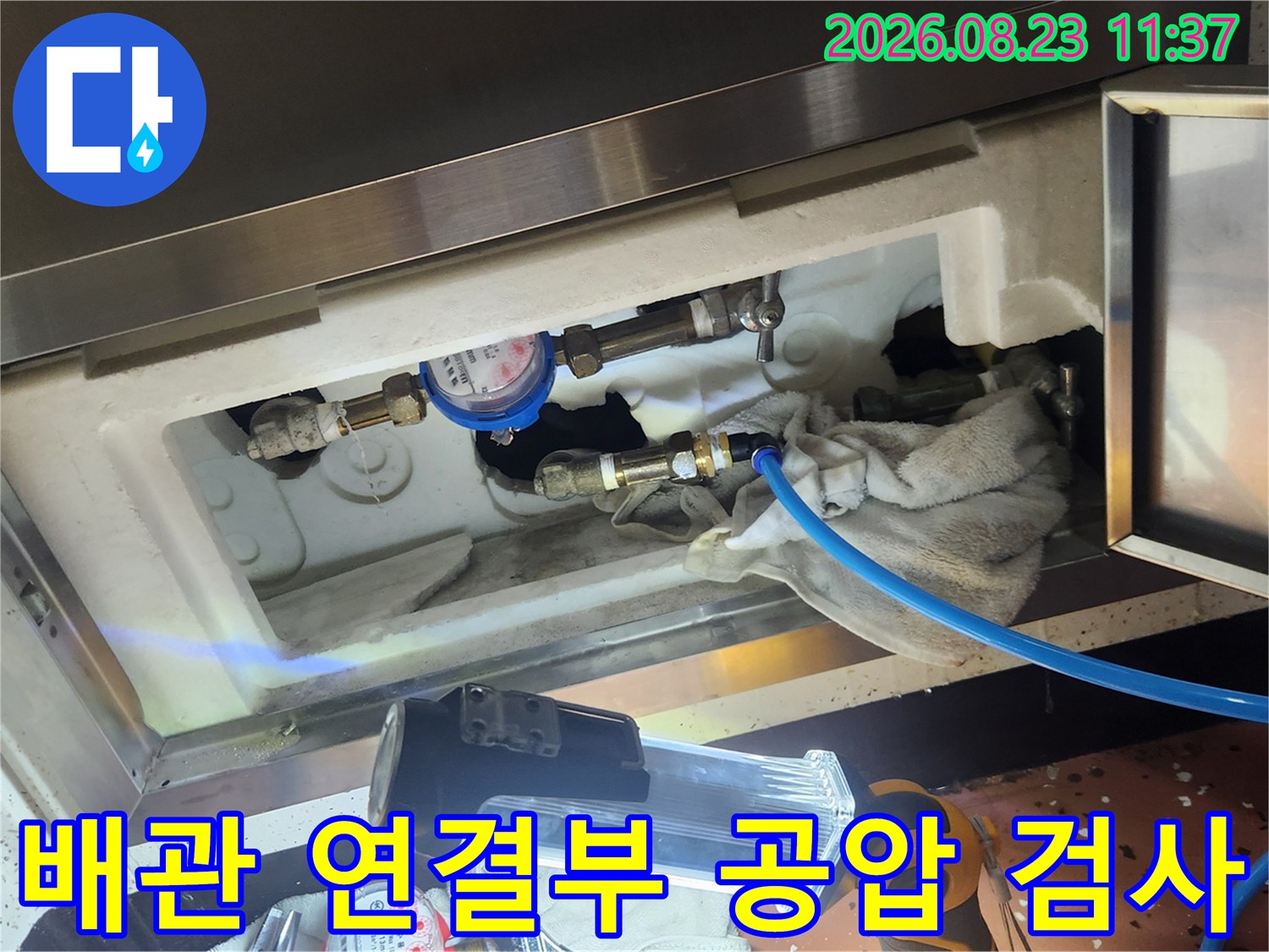 온수 배관의 누수 여부를 확인하기 위해 압력을 걸어 점검하는 장면입니다.