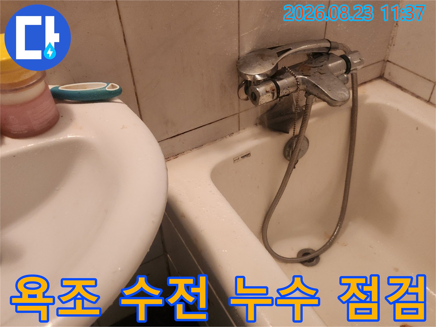 욕실 내 수전과 욕조의 연결 부위를 확인하는 모습입니다.