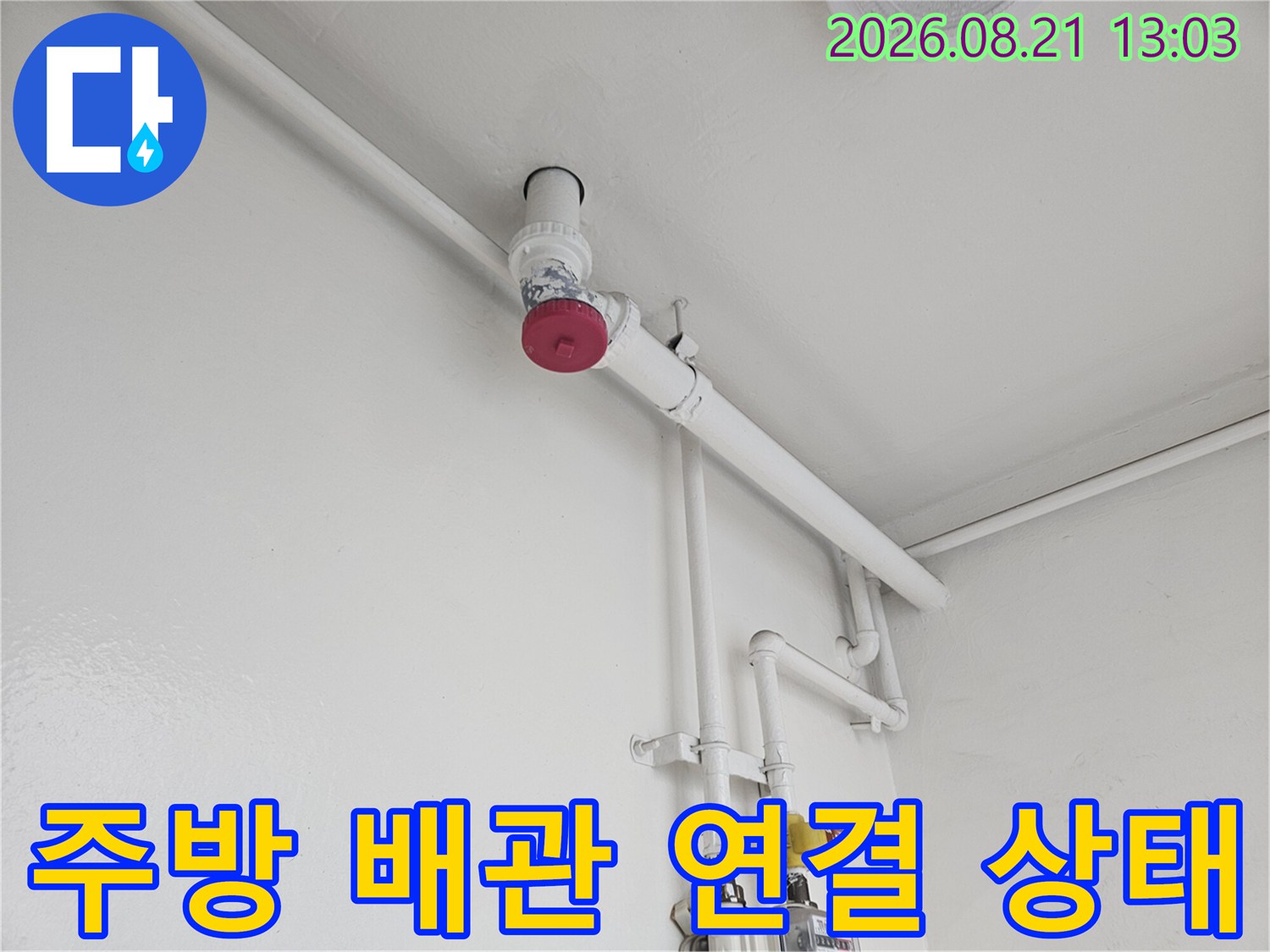 흰색으로 도장된 벽면을 따라 배치된 수도 및 하수 배관의 모습입니다.