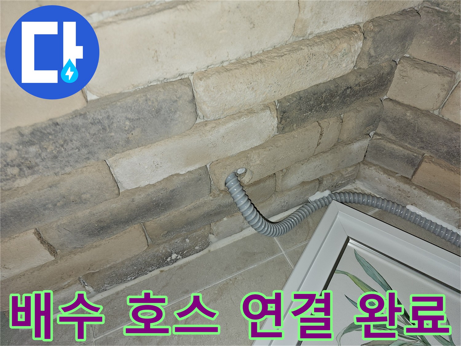 벽면 타공 부위에-설치된 회색 배수관 모습