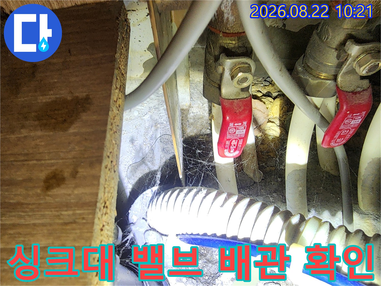 싱크대 하단 급수 밸브와 배수 호스의 연결 상태 상세 촬영