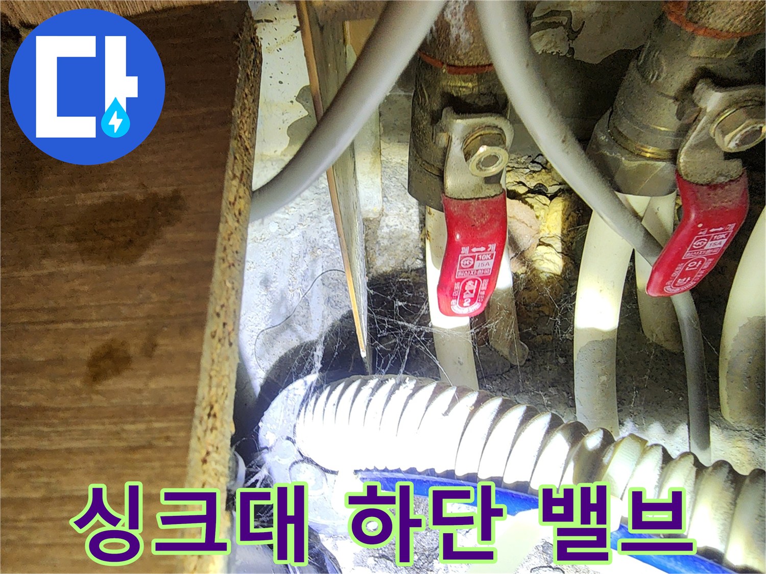 싱크대 하부장 내부 수도 밸브와 배수 호스 노후 상태
