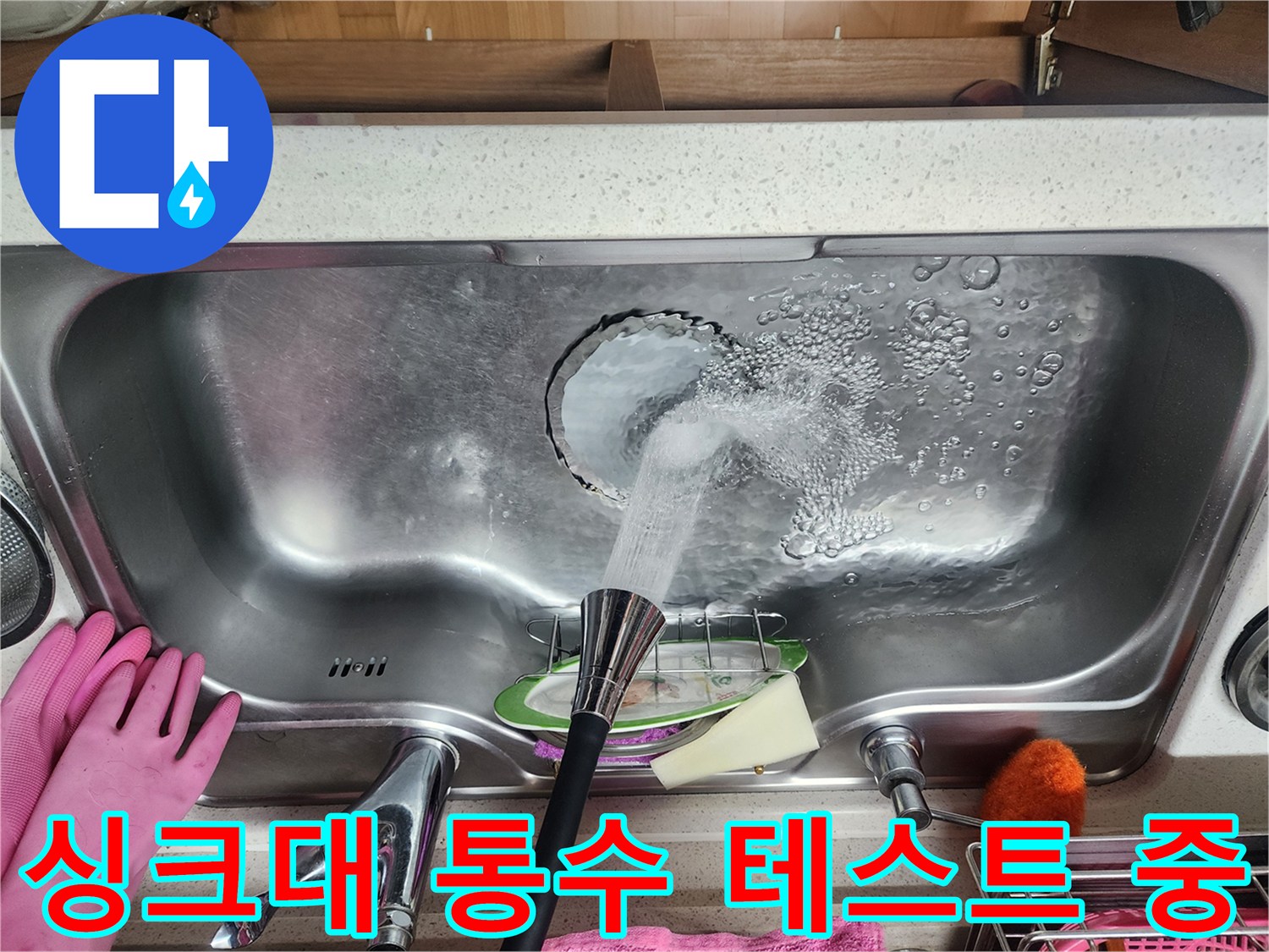 싱크대에서 물을 내려보내며 하수구 누수를 확인하는 장면입니다.