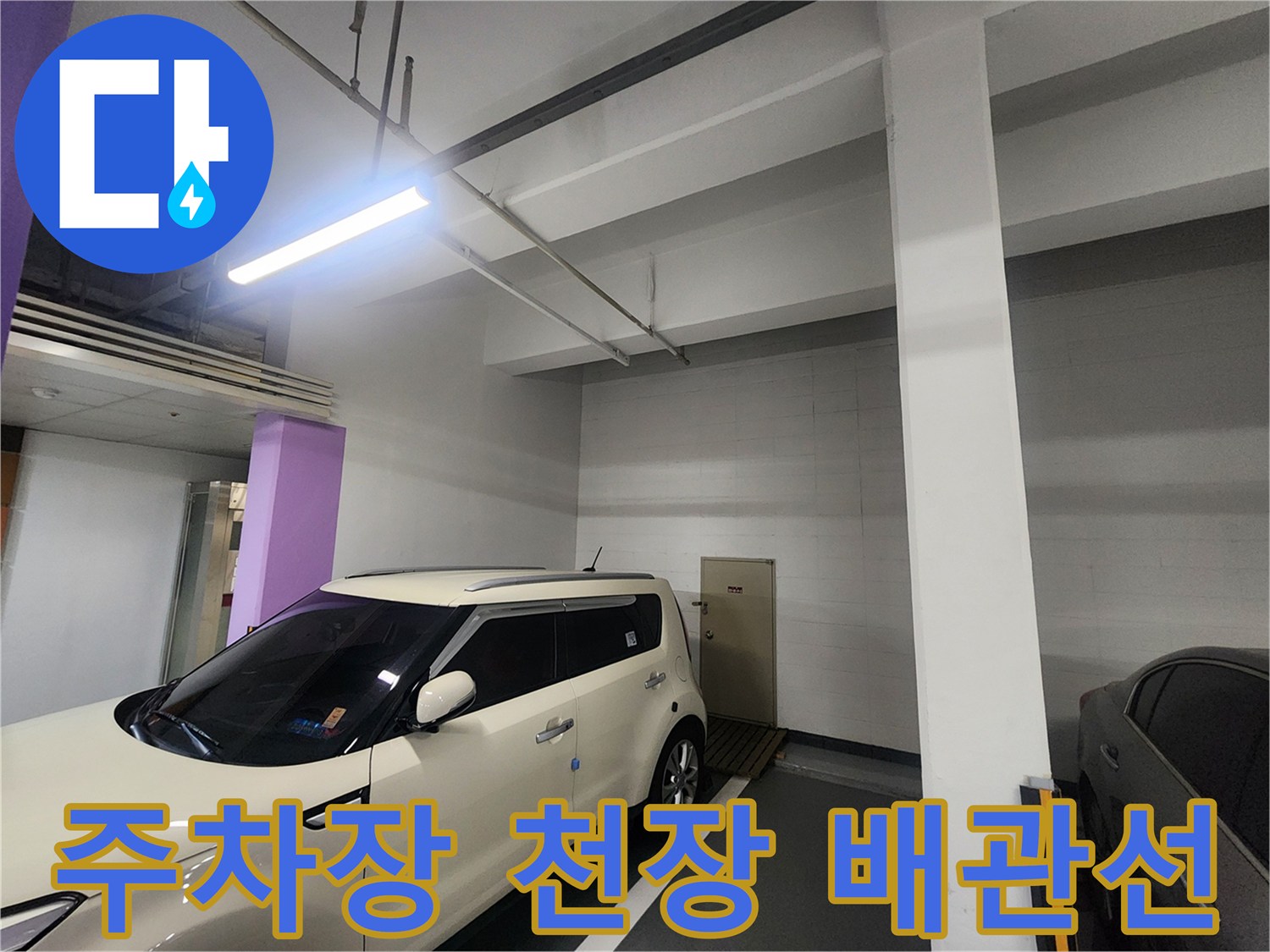 지하주차장 천장 배관과 조명 시설의 근접 모습입니다.