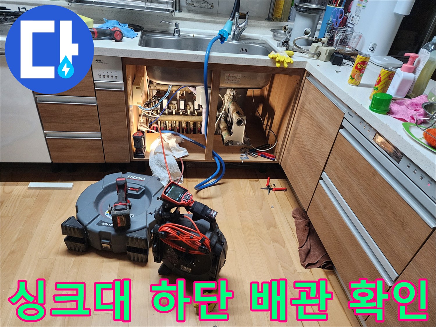 싱크대 밑부분의 배관 구조와 점검용 장비 배치 상태