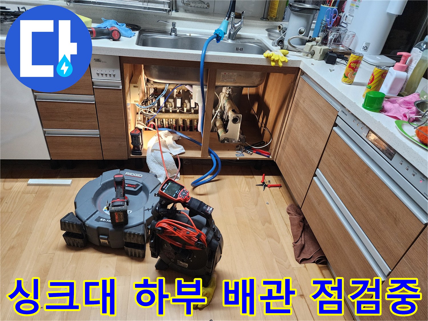 싱크대 아래쪽 배관과 작업용 전동 장비의 모습