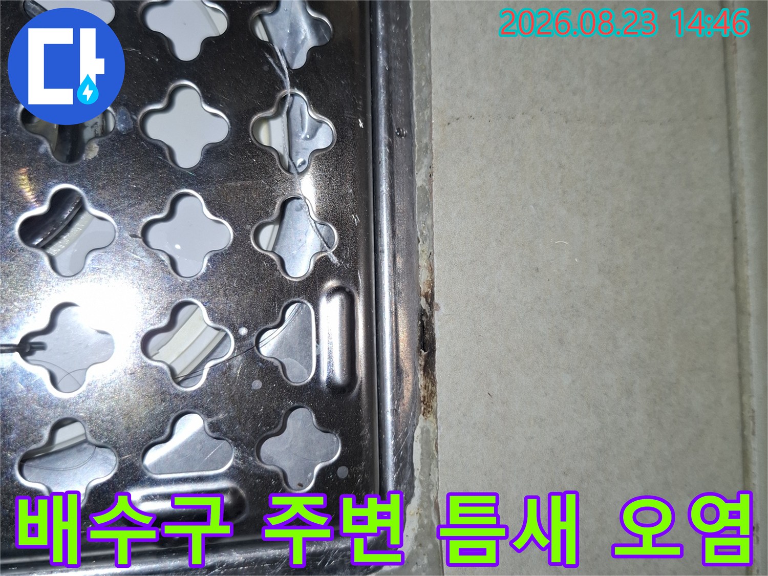 금속제 배수구 유가와 타일 접합부의 오염된 상태를 근접 촬영했습니다.