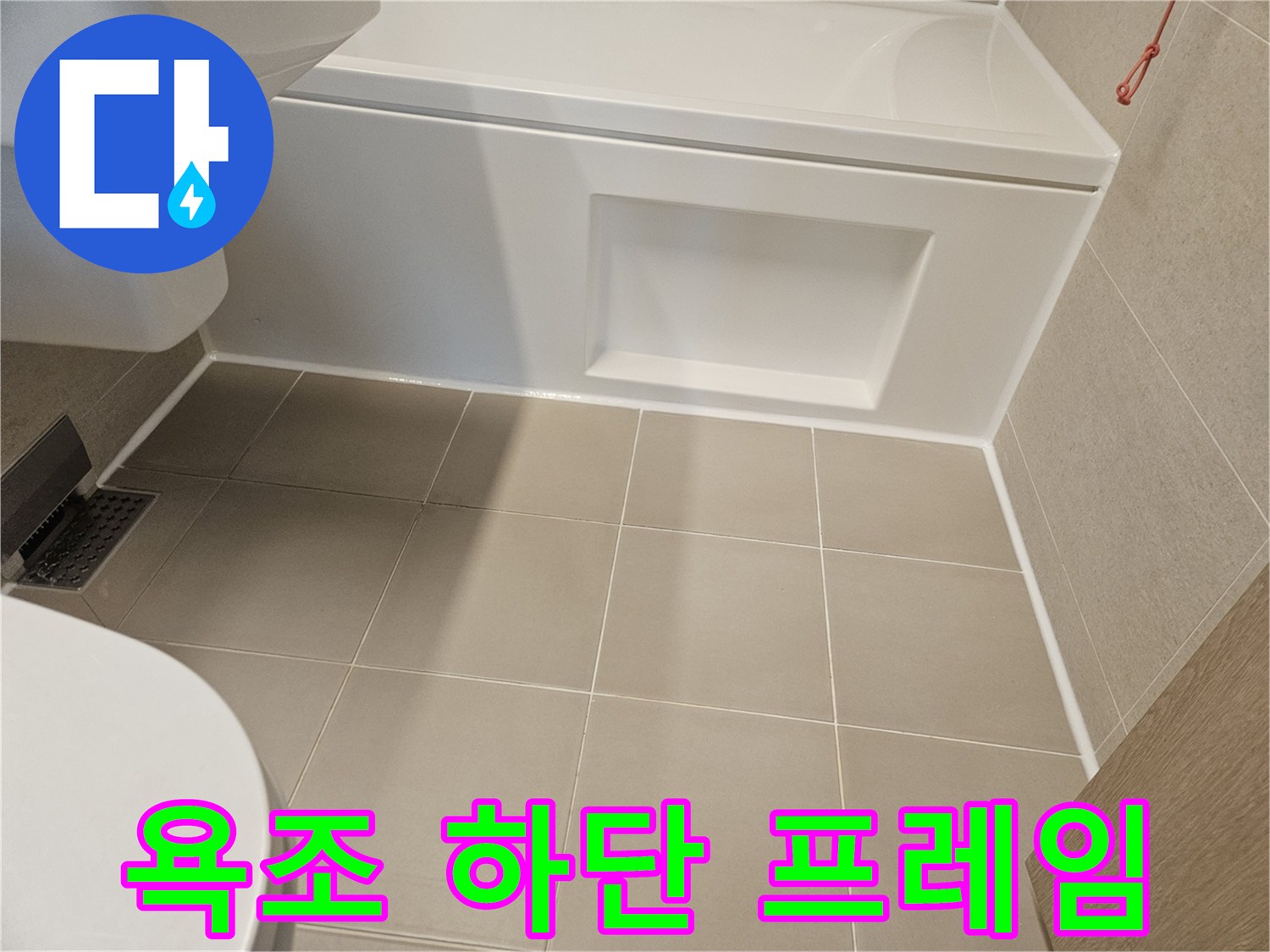 흰색 욕조 측면과 베이지색 타일의 접합부 모습