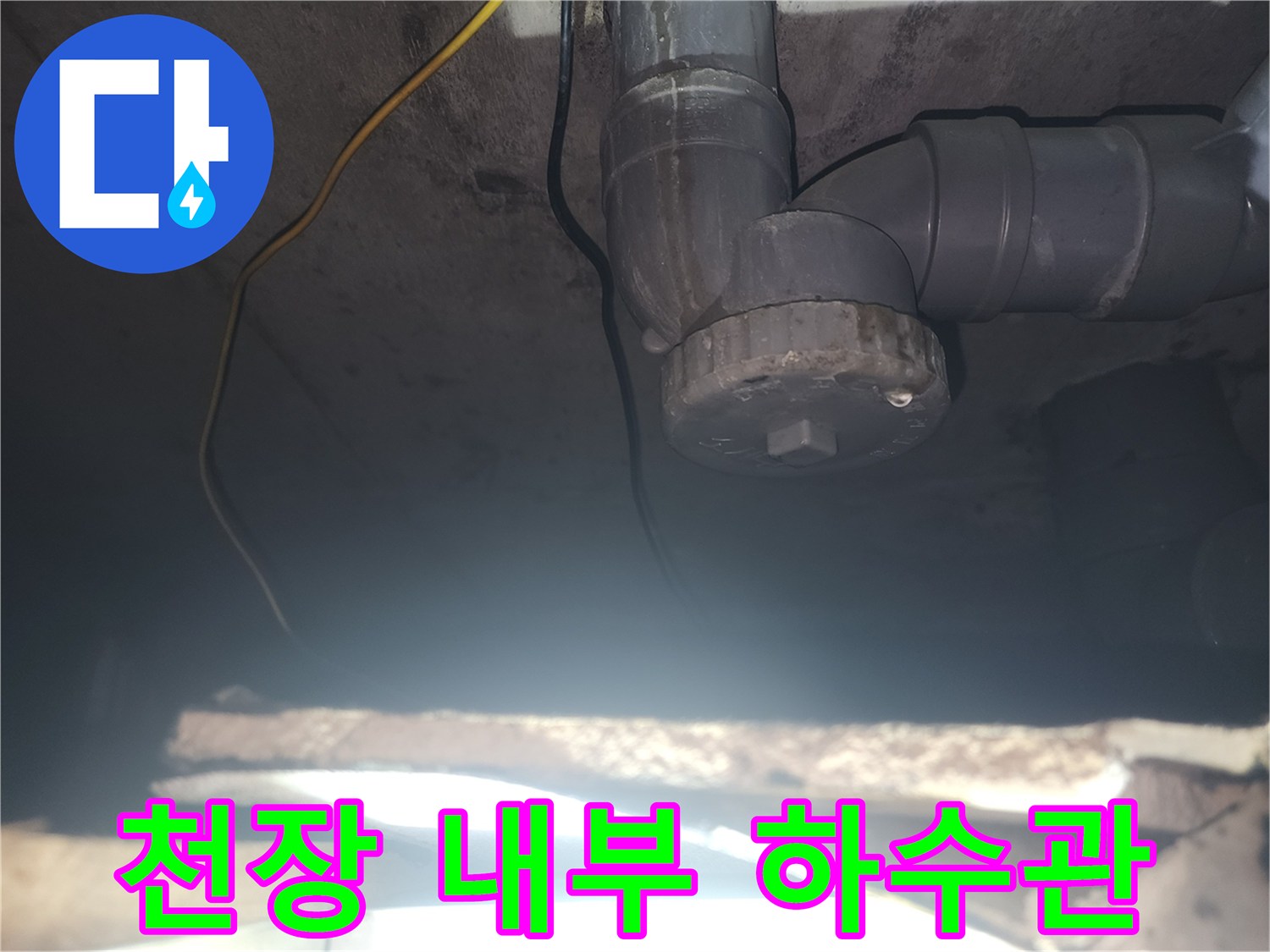 천장에 노출된 회색 PVC 배관과 연결 소켓