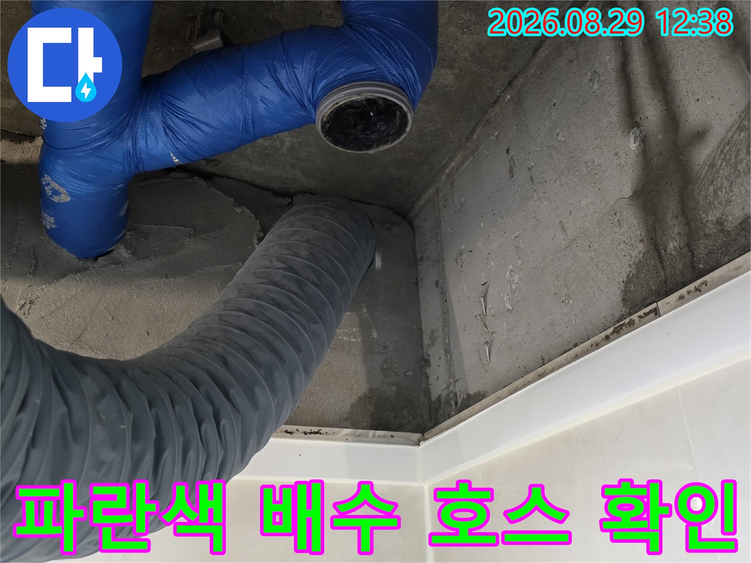천장 콘크리트 벽면과 연결된 파란색 유연한 배수 배관