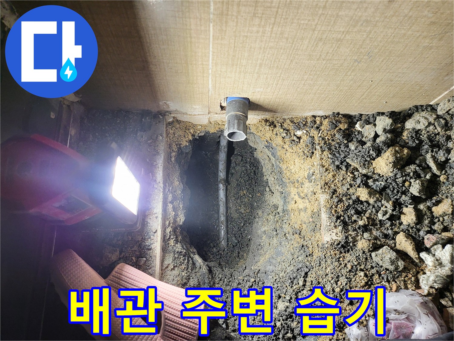 젖어 있는 흙과 노출된 파란색 배관 부속