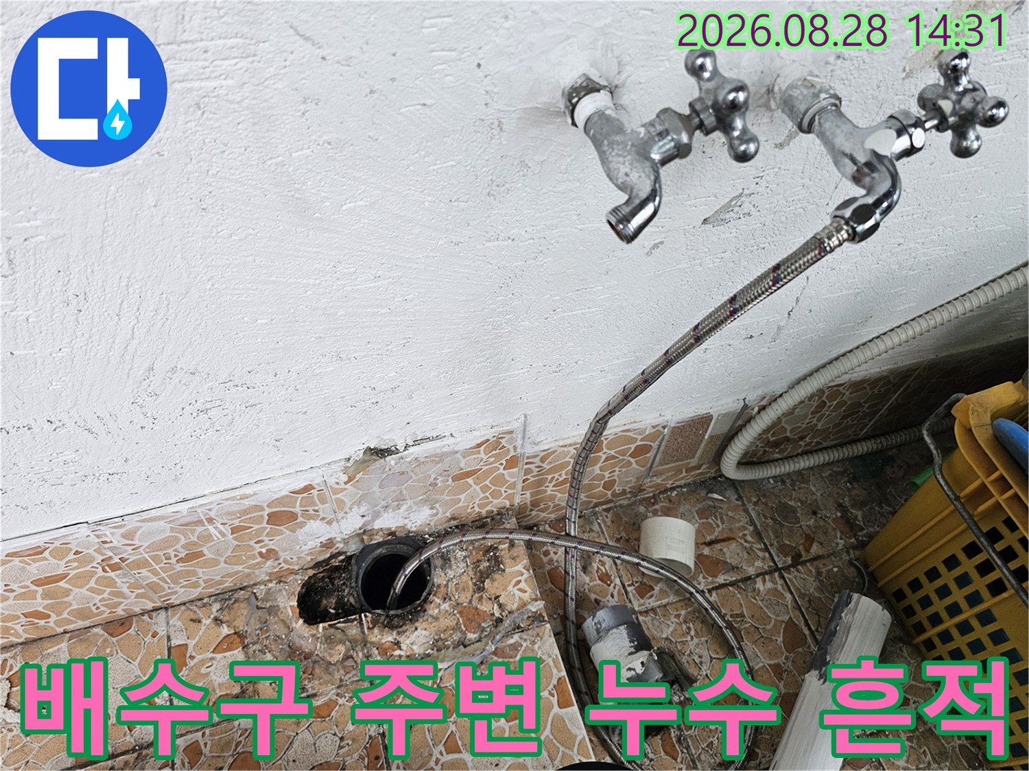 물에 젖은 타일과 노출된 배수관 연결 부위의 상세 모습