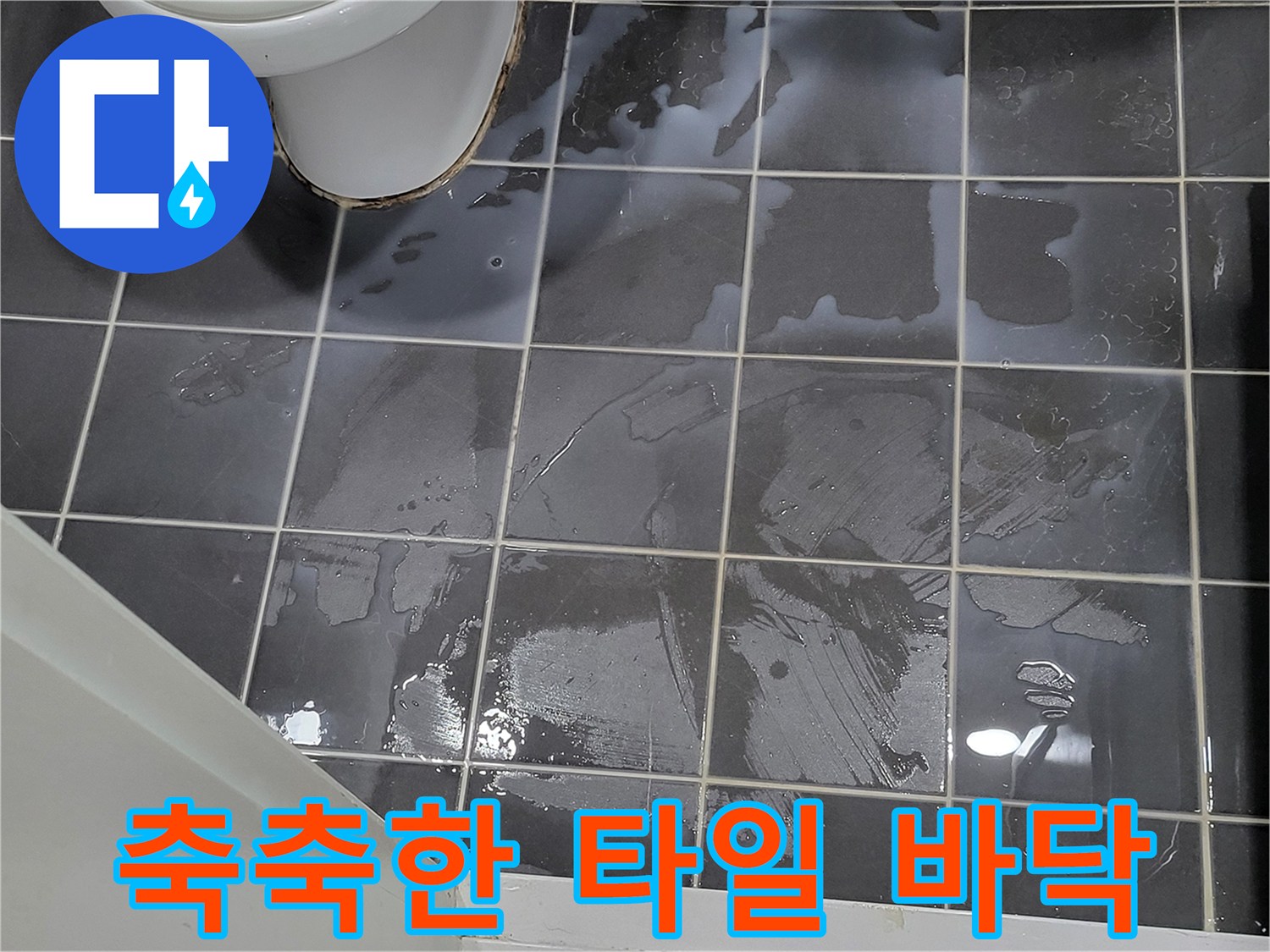물기가 흥건하게 맺힌 회색 욕실 바닥재