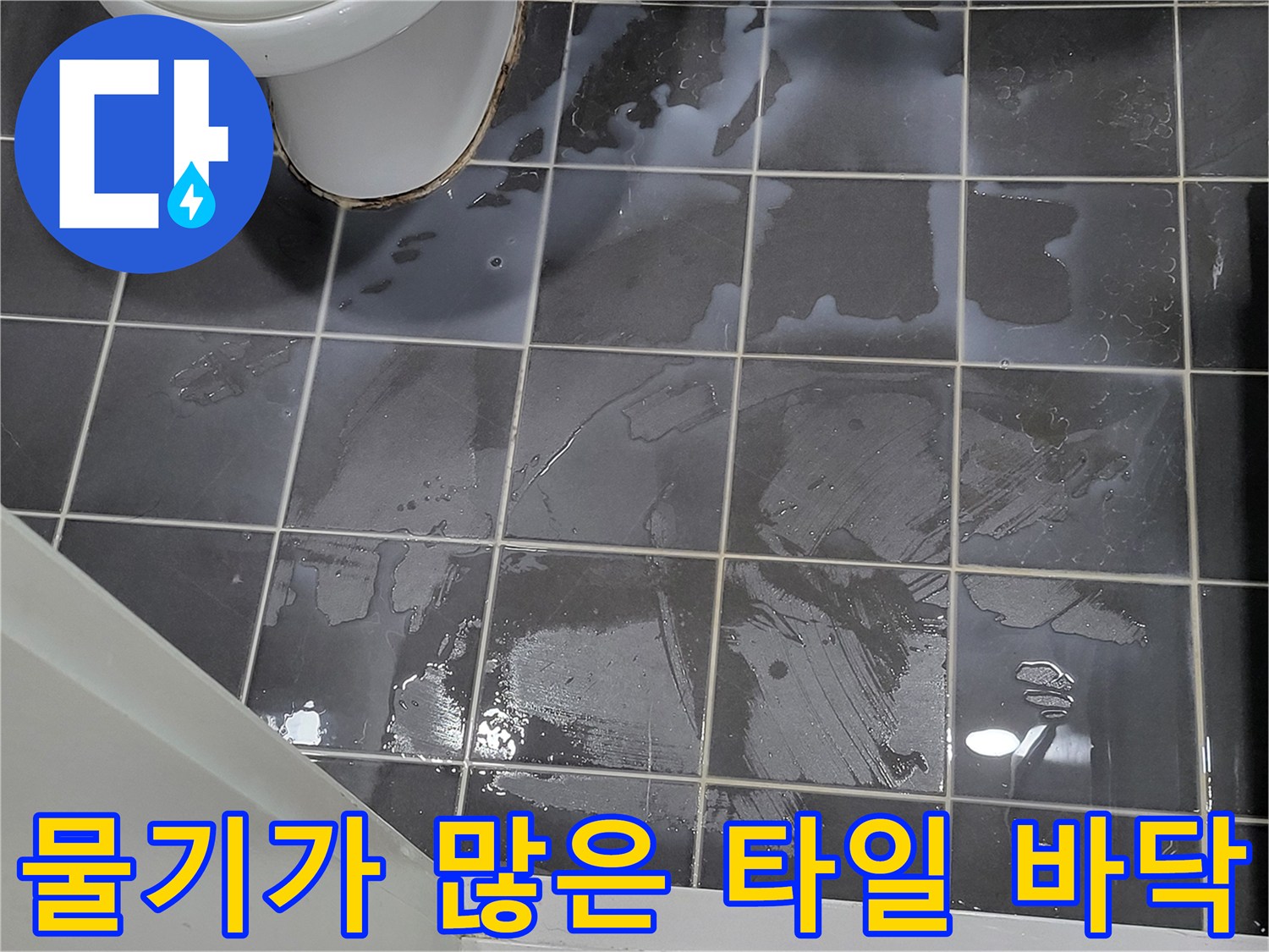 어두운 회색 타일 위에 얇게 퍼진 물층