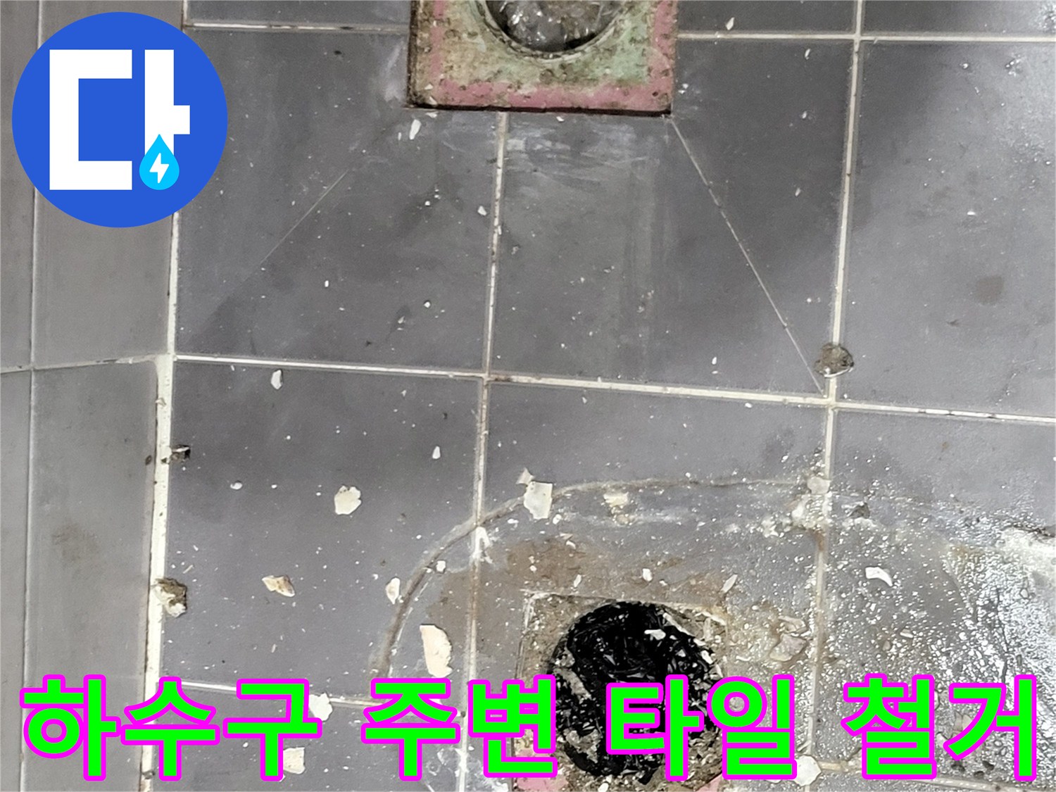 파손된 타일 사이로 보이는 배수관 입구