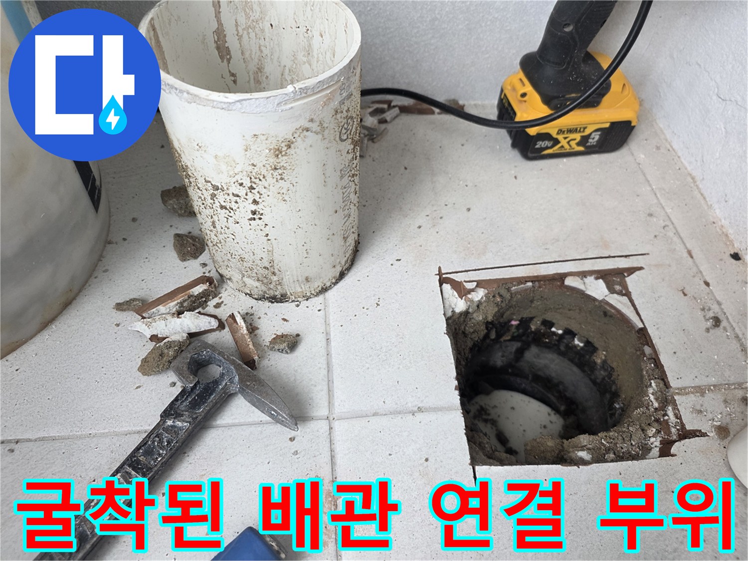 우수관 주변의 훼손된 바닥 타일과 노출된 배관 구조