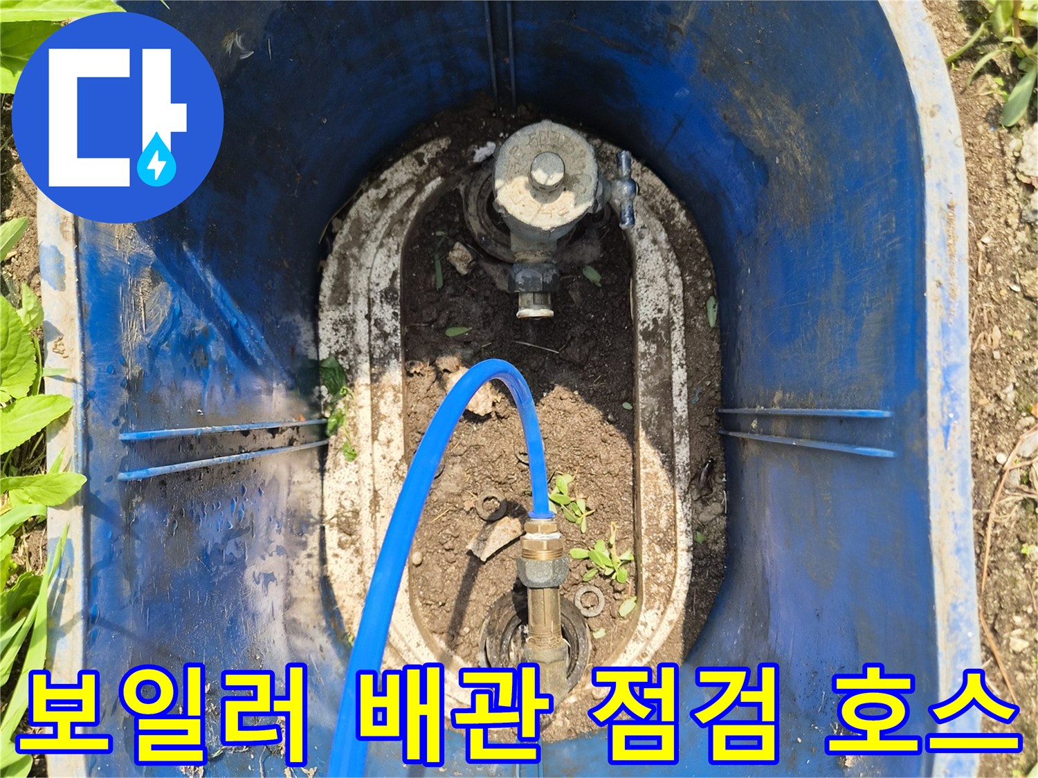 파란색 호스가 연결된 노출 배관 부속의 근접 촬영