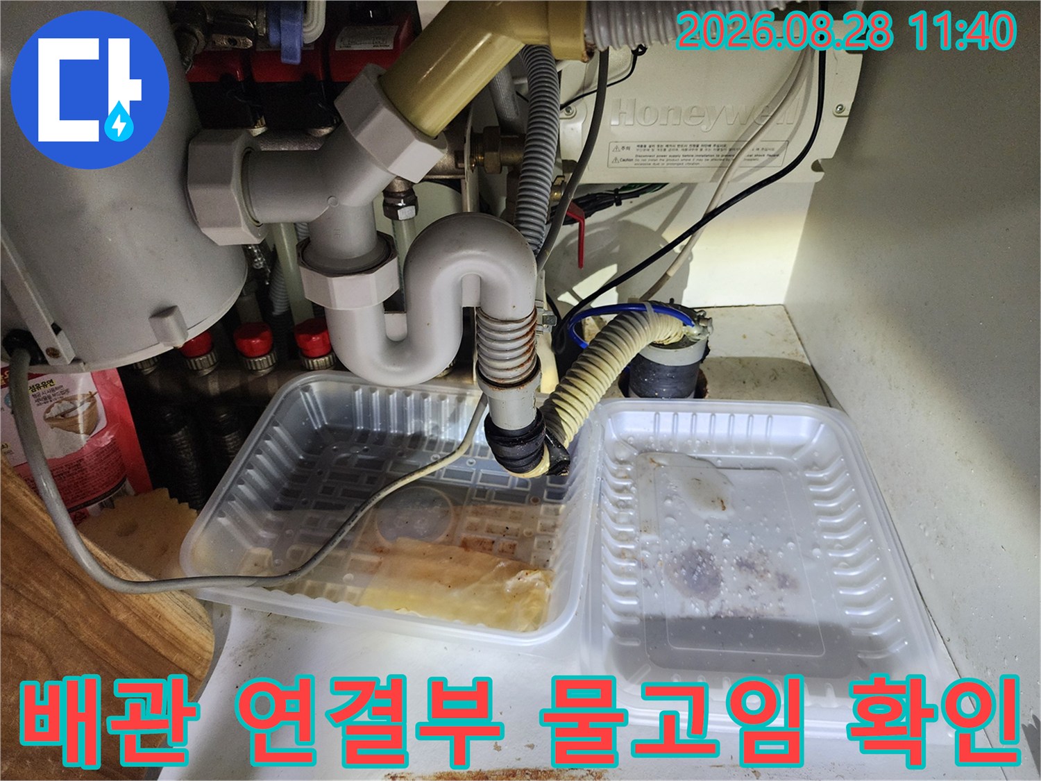 싱크대 배관 틈새에서 흘러나온 물이 트레이에 고인 장면