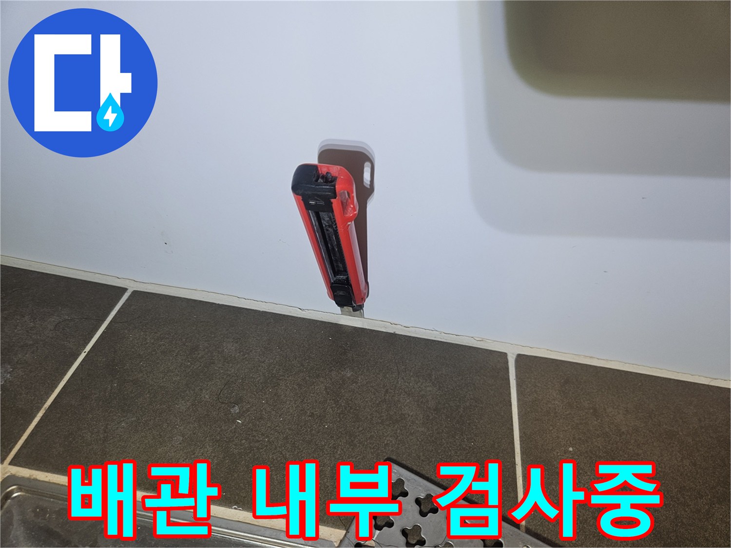 화장실 벽면 타공 부위에 삽입된 내시경 장비 모습