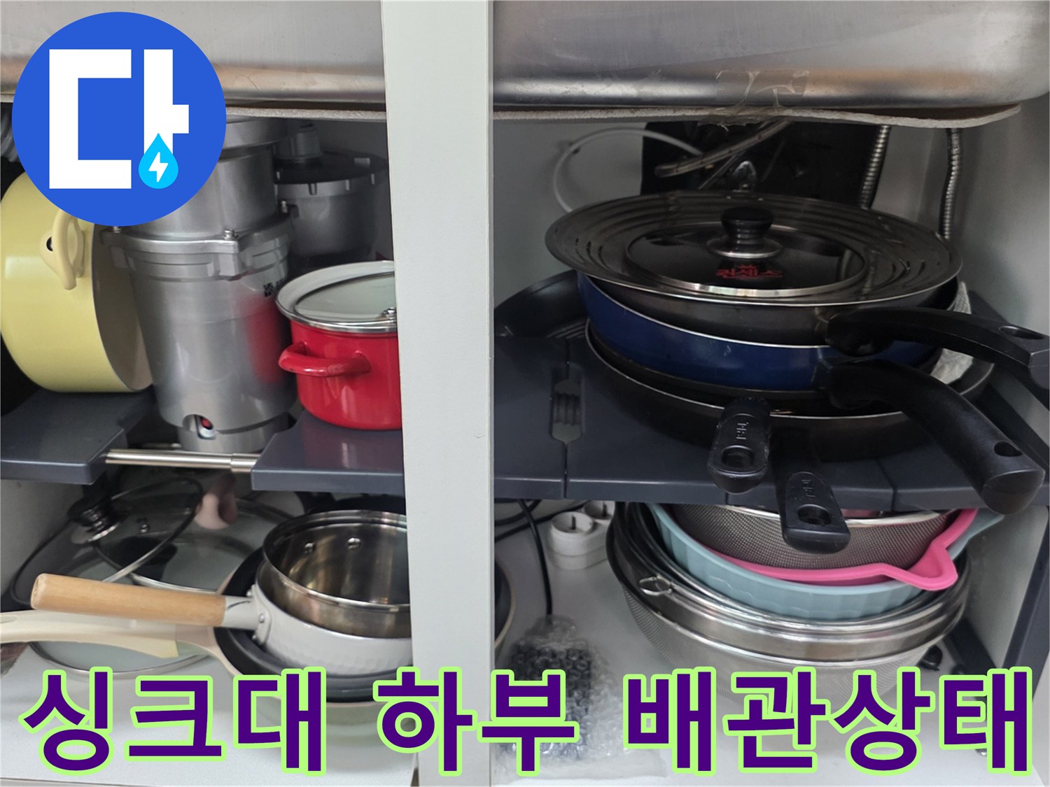 싱크대 밑 수납장 내부의 냄비와 배관 연결 부위