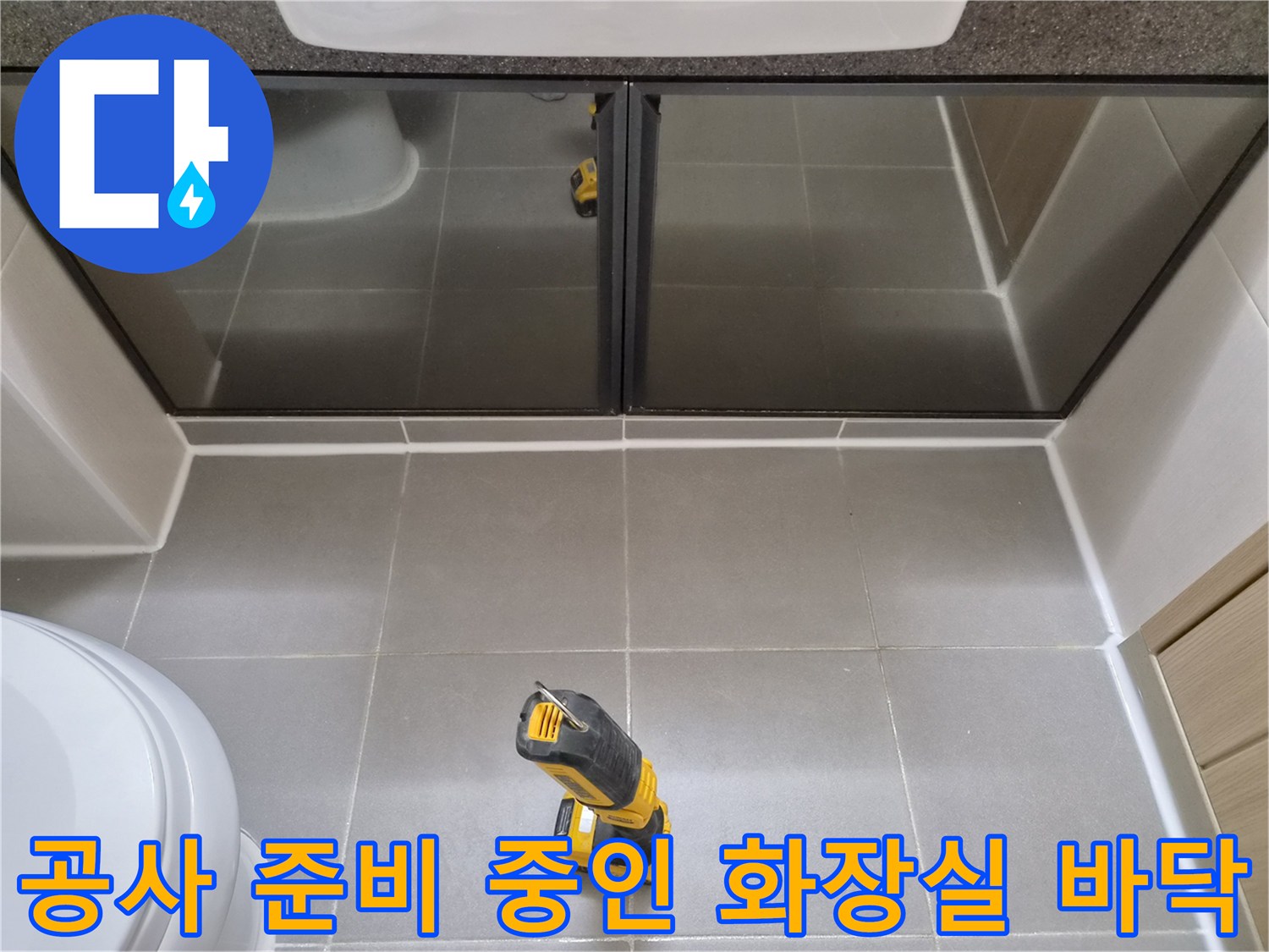 회색 욕실 타일과 전동 드릴 장비