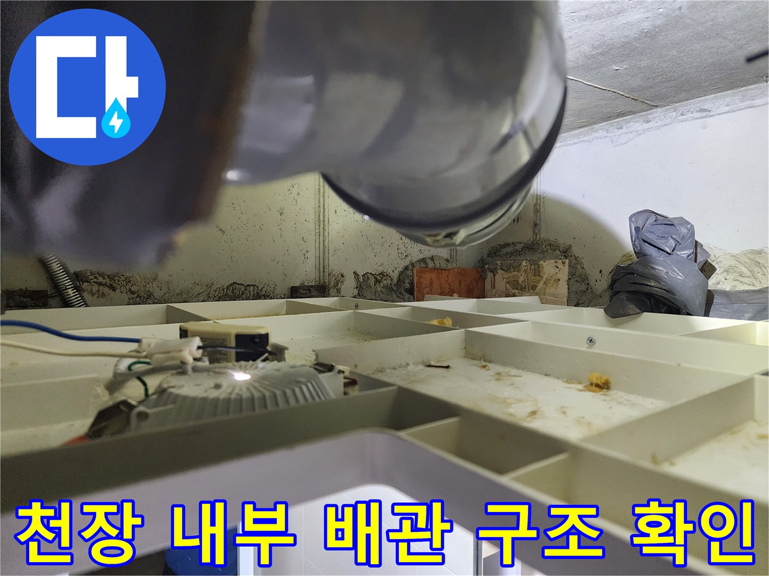 천장 점검구 안쪽의 환기 시설과 복잡한 배관 모습