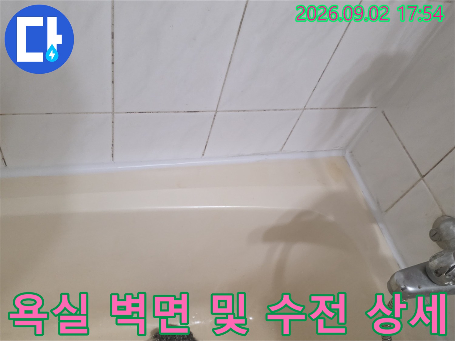 흰색 타일과 금속 소재의 욕실 수전 사진