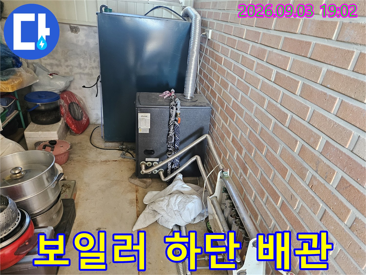 보일러와 연결된 금속 배관 및 연결 부위의 근접 사진입니다.
