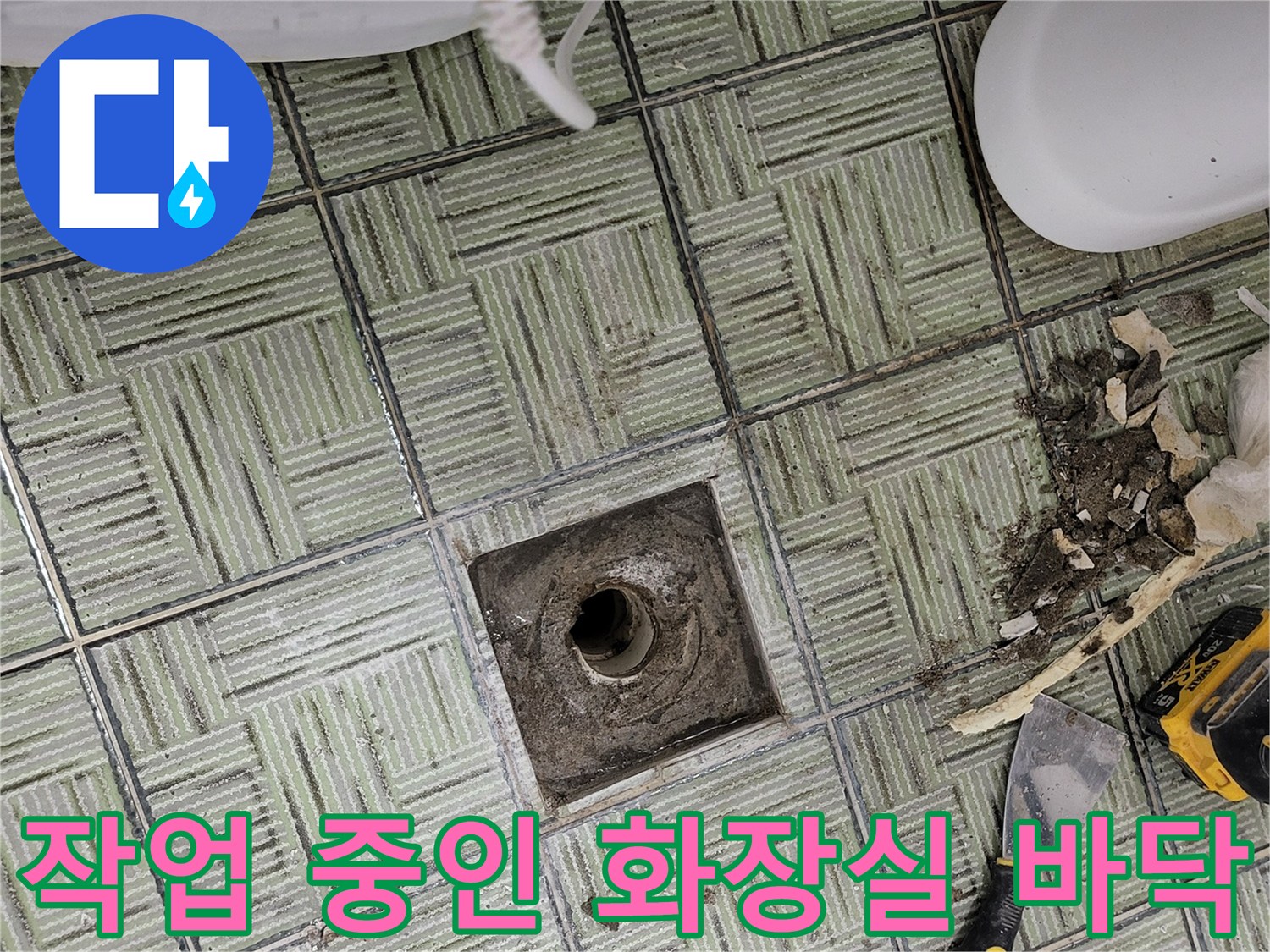 배관 주변의 젖은 타일과 공사 도구들