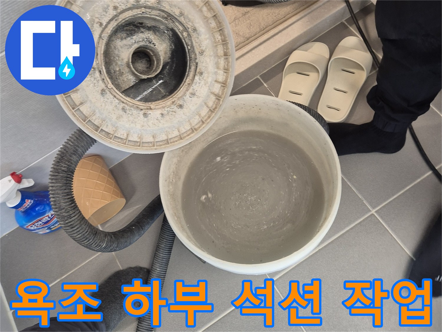 석션 장비를 활용하여-욕조 배관 주변의 고인 물을 제거하는 모습입니다