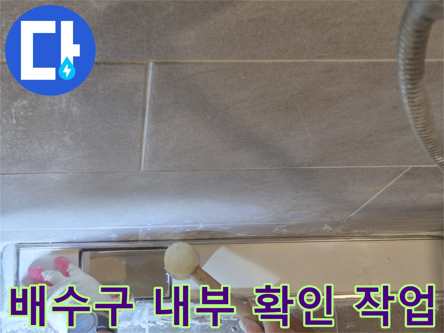 욕실 바닥 타일을 제거하여 배관의 결함을 조사하는 현장 사진