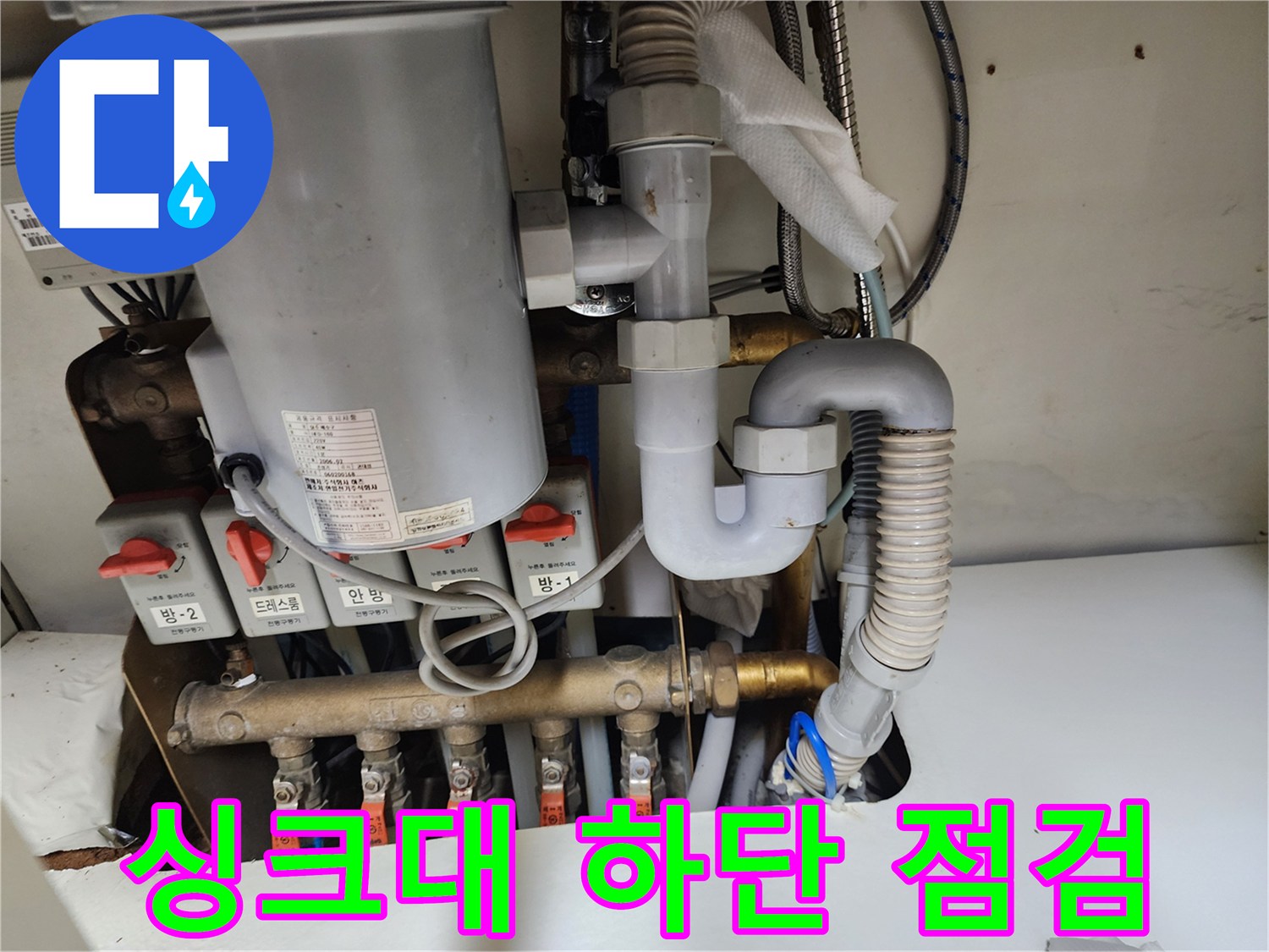 주방 싱크대 아래 수도 밸브와 호스 연결부